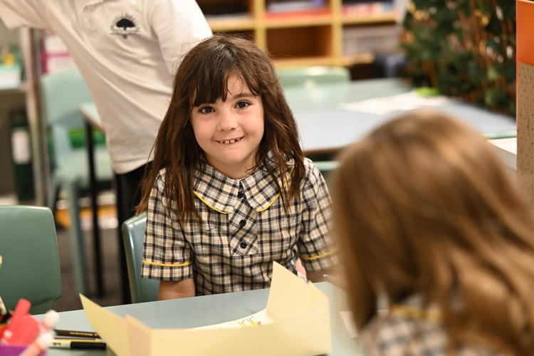 Single student in classroom smiling at camera